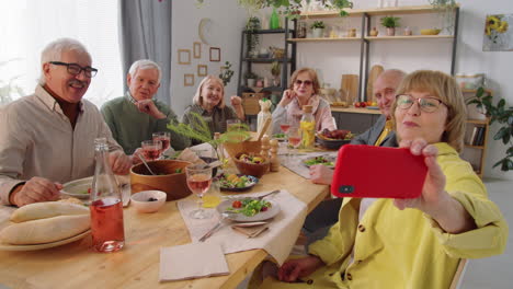 Elderly-Friends-Taking-Selfie-at-Dinner-Table